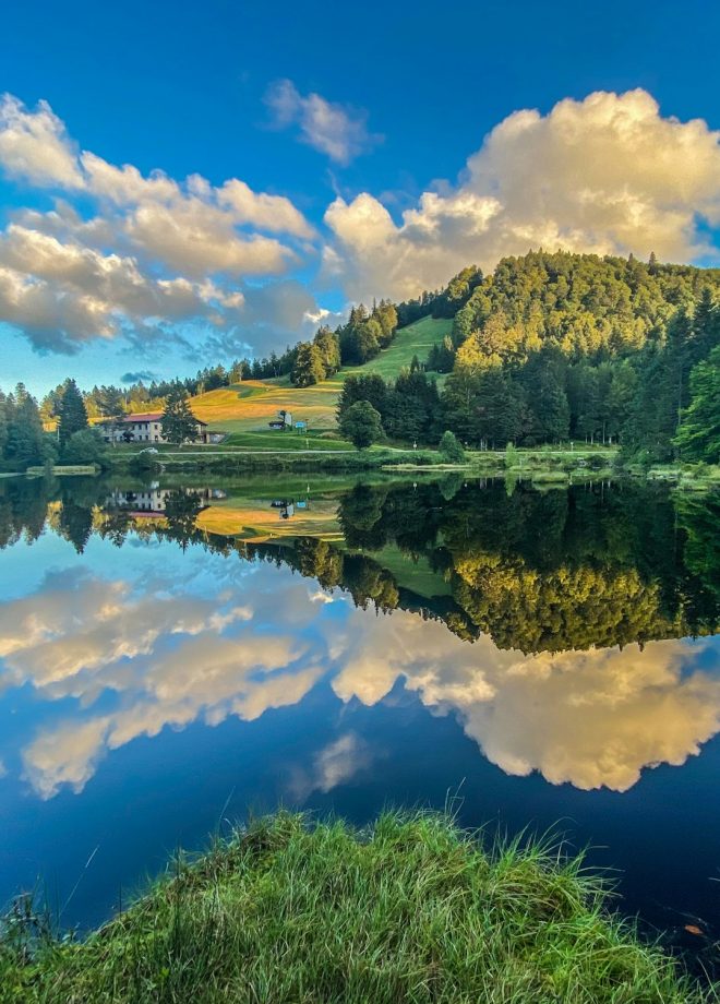 Beautiful clouds reflection in water of Lispach lake in the La Bresse, Vosges